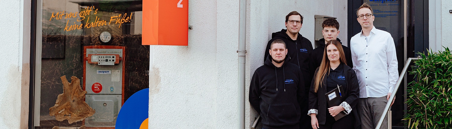 Gesamtes Team der Dornoff GmbH in Werkzeugmontur vor dem Betriebsgebaeude Dillingen